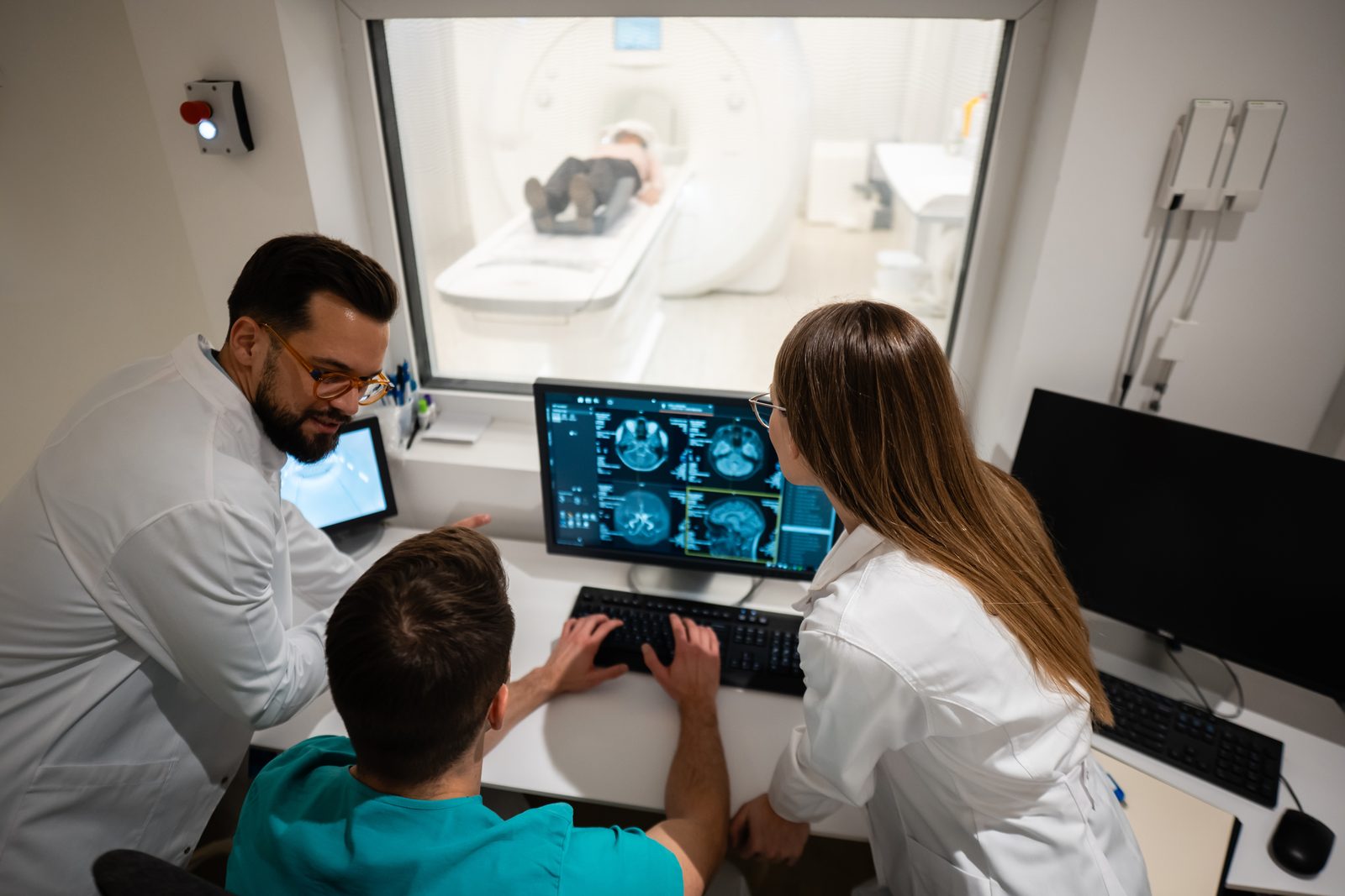 Researchers reviewing brain scans in an MRI scanner control room